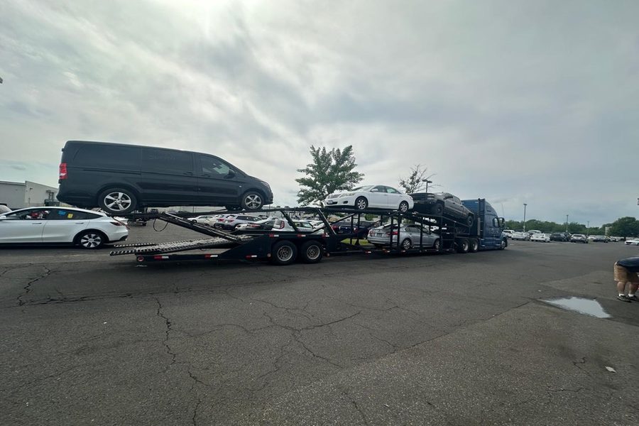 Cars secured on an open auto transport carrier