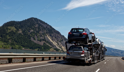 fully loaded open car shipping carrier on the motorway